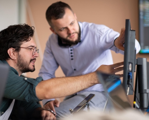 Two workers looking at computer in office